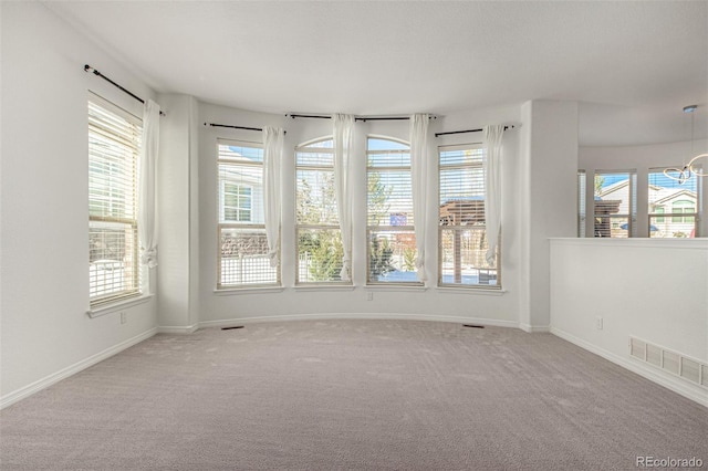 unfurnished room featuring carpet and a wealth of natural light