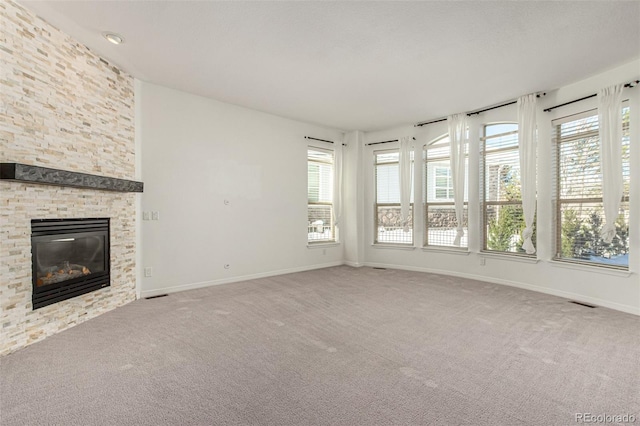 unfurnished living room with a fireplace and carpet