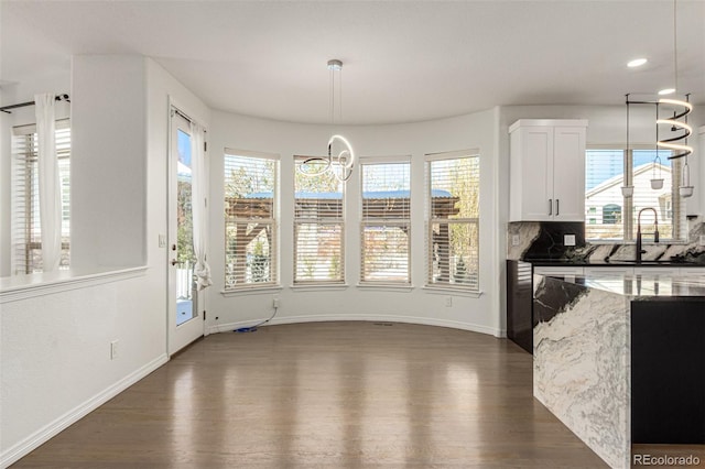 dining room with dark hardwood / wood-style flooring, an inviting chandelier, and sink