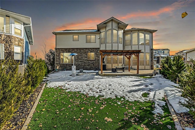 snow covered property featuring a pergola, a patio, and a yard