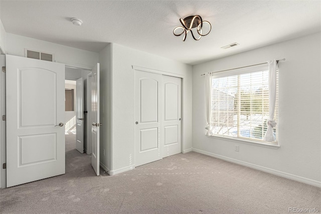 unfurnished bedroom featuring light carpet and a closet