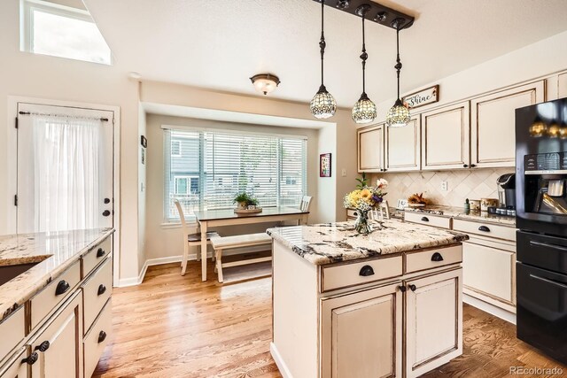 5133 E Essex Ave, Castle Rock, CO 80104 - kitchen featuring black fridge with ice dispenser, light wood-style floors, backsplash, and cream cabinetry
