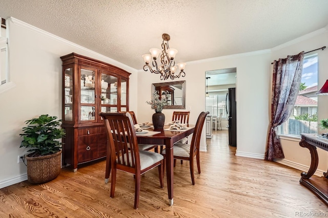5133 E Essex Ave, Castle Rock, CO 80104 - dining area featuring light wood-type flooring, a chandelier, plenty of natural light, crown molding, and a textured ceiling
