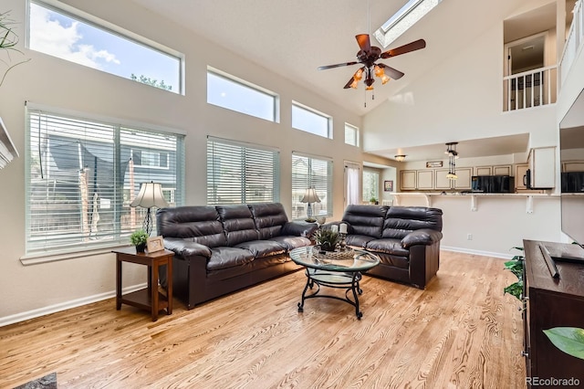 5133 E Essex Ave, Castle Rock, CO 80104 - living area with a ceiling fan, light wood-style flooring, a towering ceiling, and a skylight
