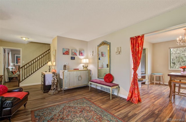 3006 Oro Blanco Dr, Colorado Springs, CO 80917 - living area featuring wood finished floors, baseboards, a textured ceiling, stairs, and a notable chandelier