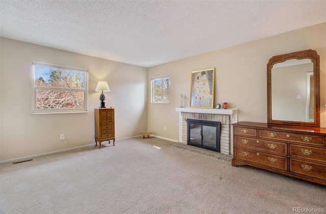 3006 Oro Blanco Dr, Colorado Springs, CO 80917 - carpeted living room featuring a textured ceiling, a brick fireplace, visible vents, and baseboards