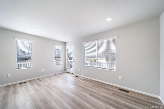 spare room featuring light wood-type flooring, baseboards, and recessed lighting