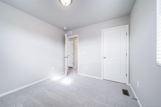 unfurnished bedroom featuring carpet and baseboards