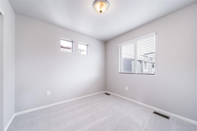 carpeted spare room featuring baseboards
