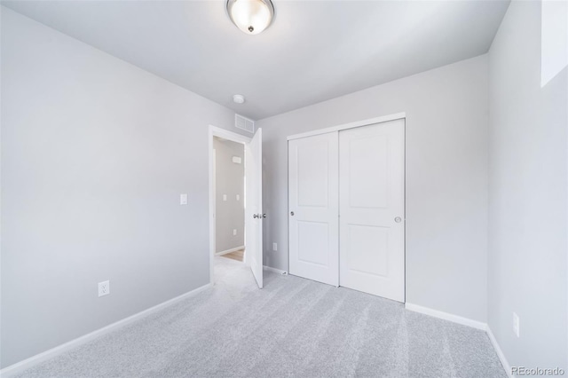 unfurnished bedroom with baseboards, carpet floors, and a closet
