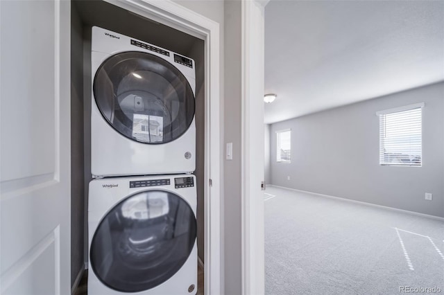 laundry room featuring estacked washer and dryer, carpet, and baseboards