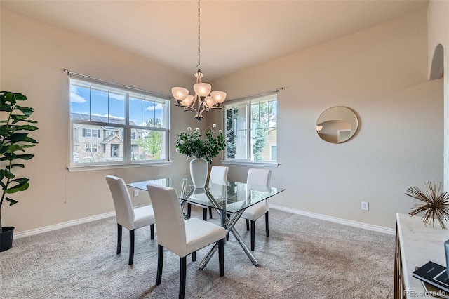 dining area with carpet flooring, baseboards, and a chandelier