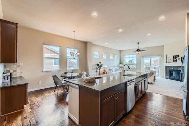 kitchen featuring a premium fireplace, open floor plan, appliances with stainless steel finishes, and a sink