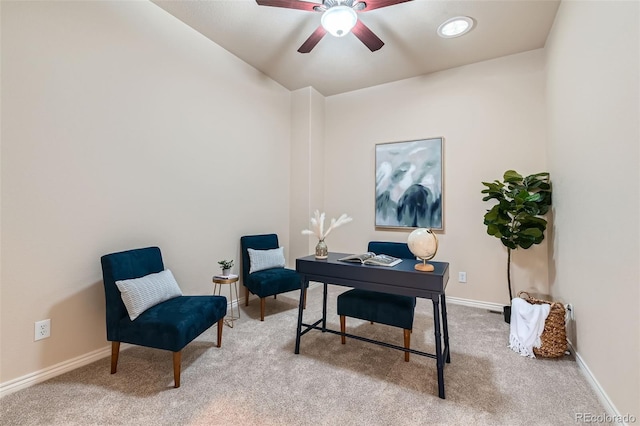 carpeted office space featuring a ceiling fan and baseboards