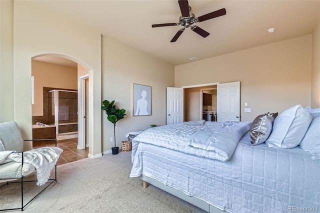 bedroom featuring ceiling fan, arched walkways, vaulted ceiling, baseboards, and carpet