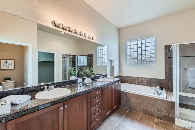 bathroom featuring a sink, double vanity, tile patterned floors, a garden tub, and a stall shower