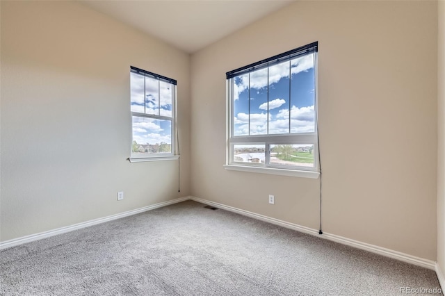 unfurnished room with carpet flooring, baseboards, and a healthy amount of sunlight