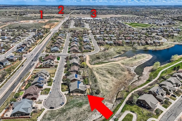 drone / aerial view with a water view and a residential view