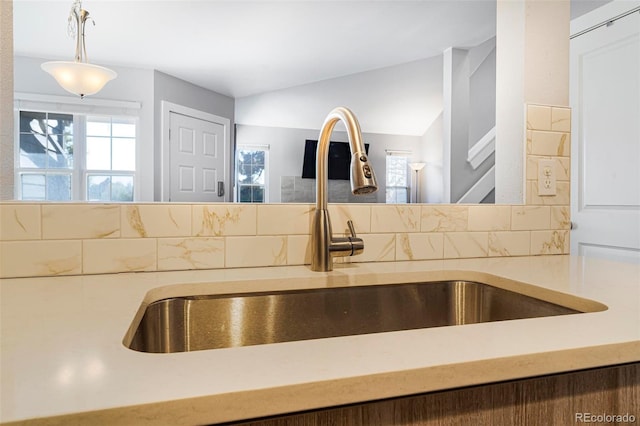 kitchen featuring backsplash, sink, and pendant lighting