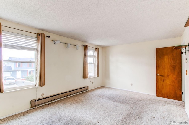 unfurnished room featuring baseboard heating, a textured ceiling, and carpet floors