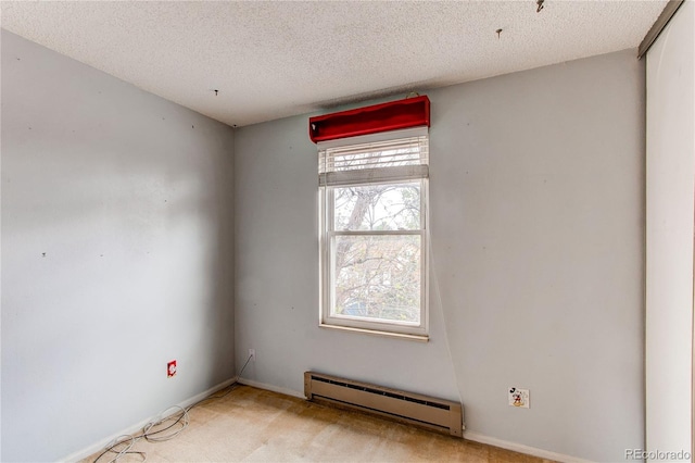 unfurnished room featuring a baseboard heating unit, a textured ceiling, and light colored carpet