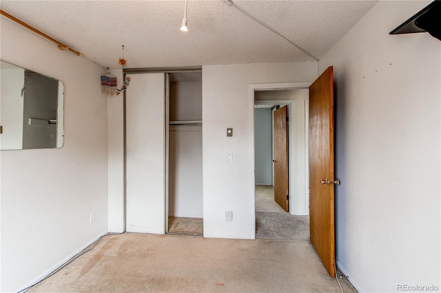 unfurnished bedroom featuring carpet floors, a closet, and a textured ceiling