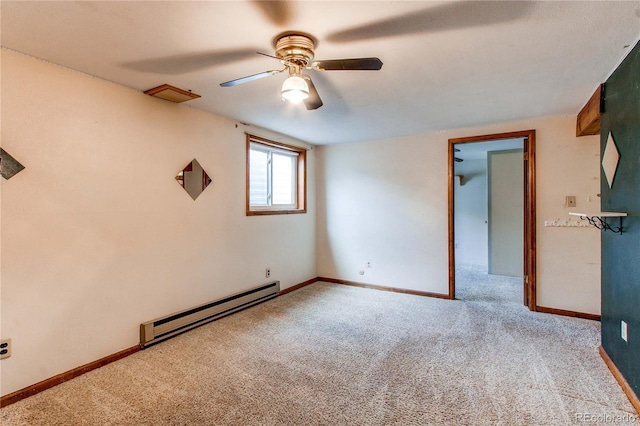 carpeted empty room with a baseboard heating unit, ceiling fan, and baseboards