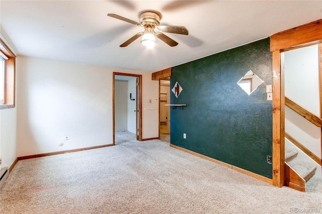 unfurnished room with carpet, ceiling fan, and baseboards