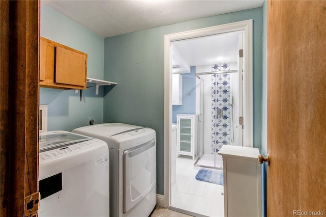 clothes washing area with washing machine and dryer and light tile patterned floors