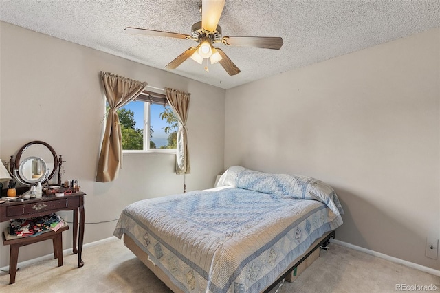 bedroom with a textured ceiling, light carpet, and ceiling fan