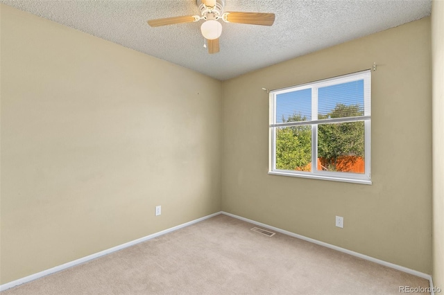 carpeted spare room featuring a textured ceiling and ceiling fan