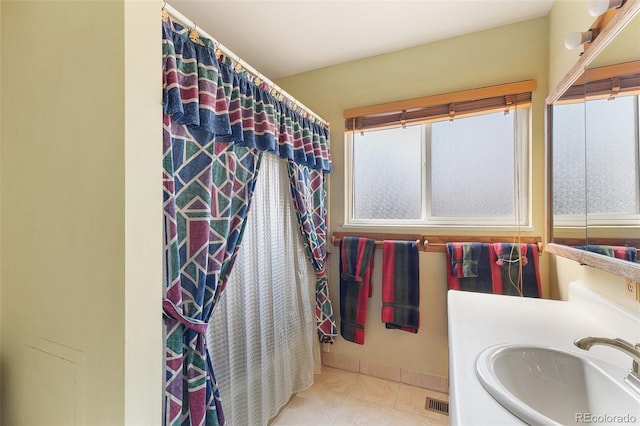 bathroom featuring vanity, walk in shower, a healthy amount of sunlight, and tile patterned floors