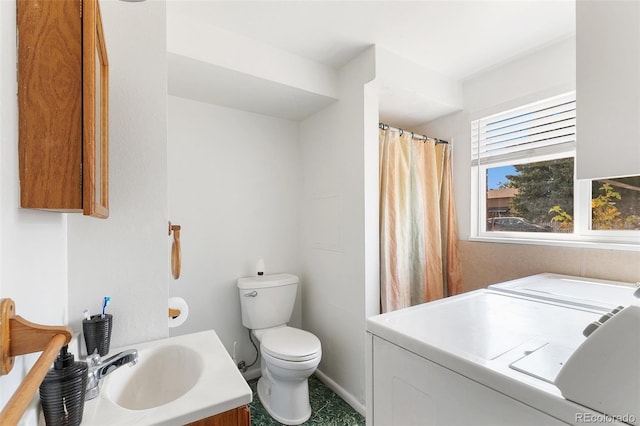 bathroom with washer and dryer, vanity, and toilet