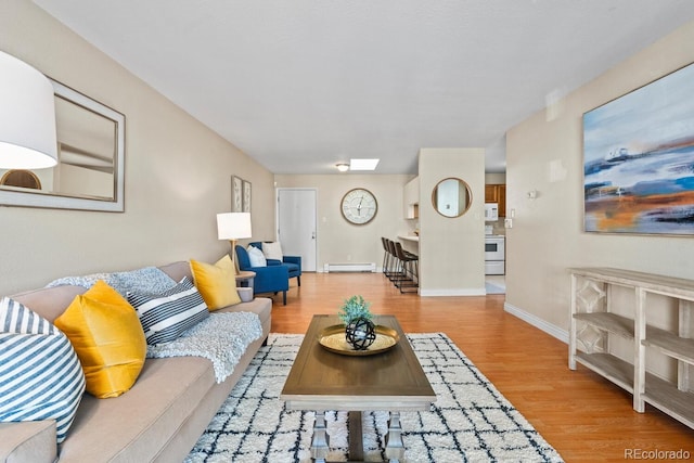 living room with a baseboard heating unit and hardwood / wood-style floors