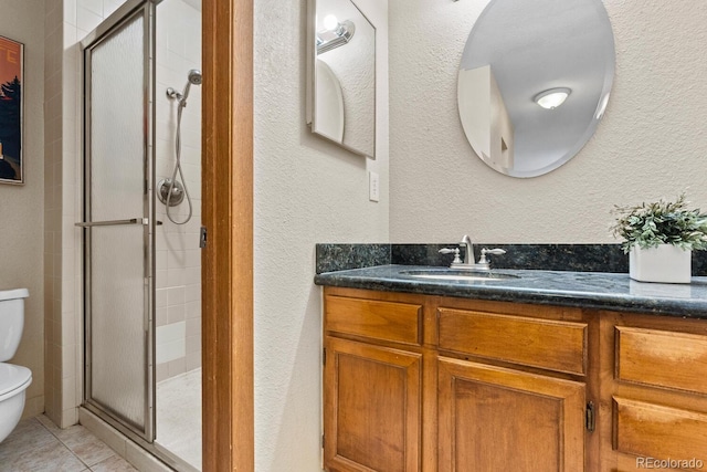 bathroom with vanity, toilet, tile patterned flooring, and a shower with door