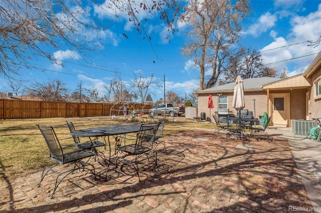 view of yard featuring outdoor dining space, cooling unit, fence private yard, and a patio