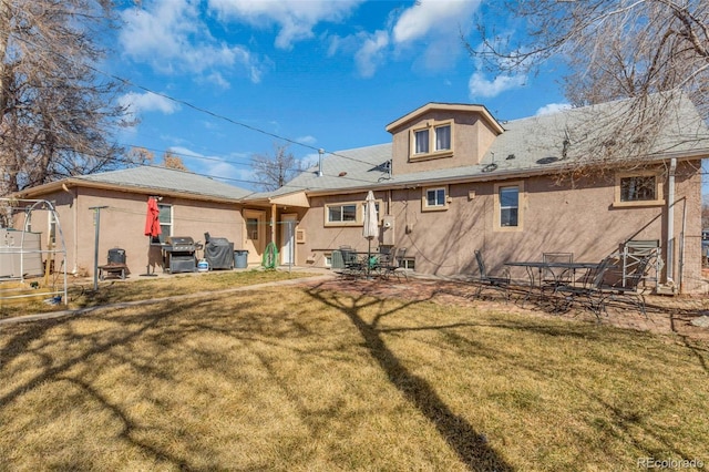 back of property featuring a yard, a patio area, cooling unit, and stucco siding