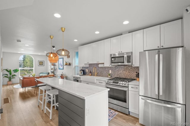 3317 W 37th Ave, Denver, CO 80211 - kitchen featuring a center island, appliances with stainless steel finishes, a sink, and white cabinetry