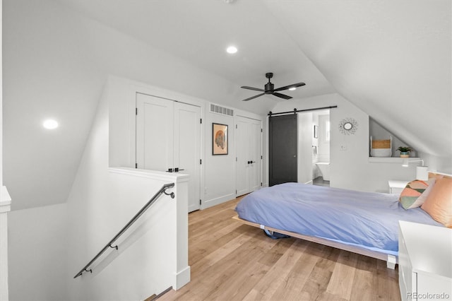 3317 W 37th Ave, Denver, CO 80211 - bedroom with light wood-style flooring, a barn door, vaulted ceiling, visible vents, and multiple closets