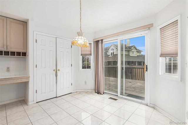 unfurnished dining area with baseboards and visible vents