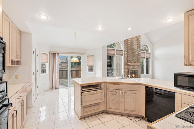 kitchen with light brown cabinets, a fireplace, tile countertops, a sink, and black appliances