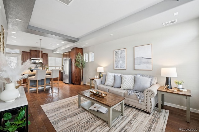 living area featuring hardwood / wood-style flooring, baseboards, and visible vents