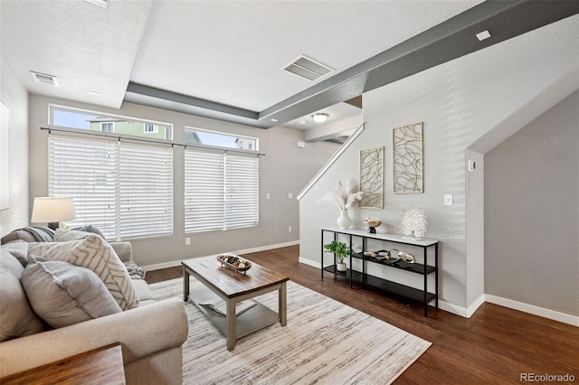 living area featuring wood finished floors, visible vents, and baseboards