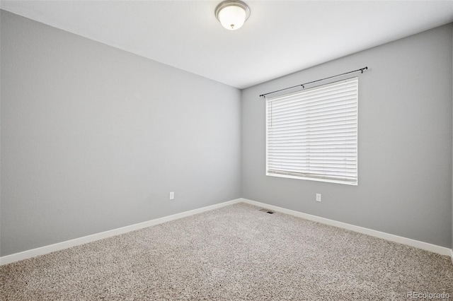 carpeted spare room featuring visible vents and baseboards