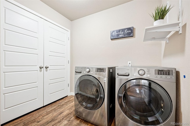 laundry room featuring laundry area, wood finished floors, and washer and dryer