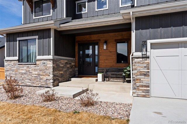 view of exterior entry with a porch, board and batten siding, and stone siding