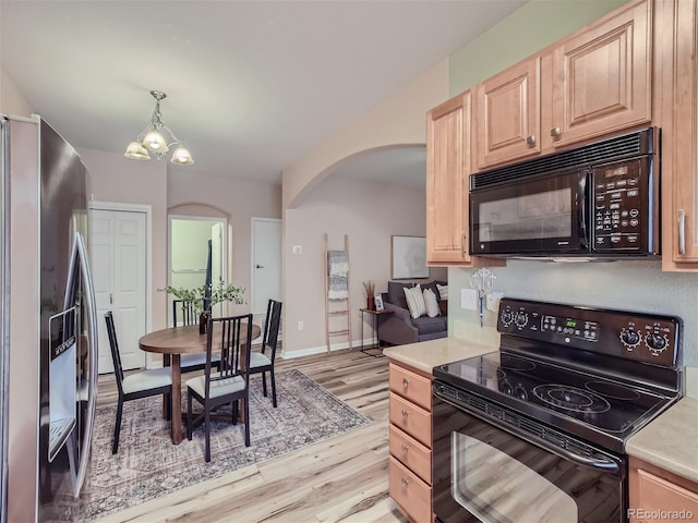 kitchen featuring pendant lighting, light wood-type flooring, a notable chandelier, black appliances, and light brown cabinetry