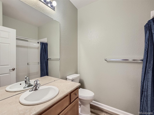 bathroom featuring toilet, wood finished floors, a shower with shower curtain, baseboards, and vanity