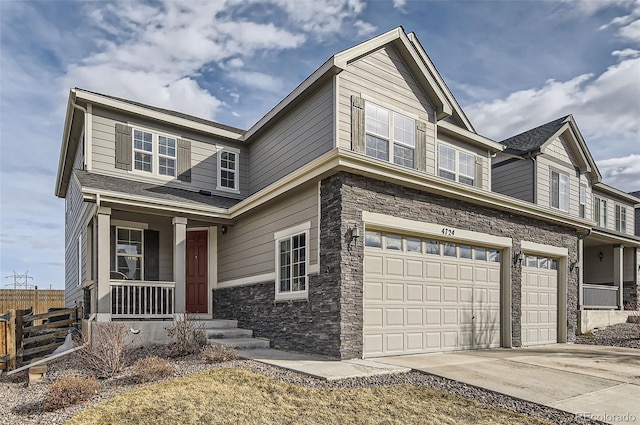 view of front of property featuring an attached garage, covered porch, fence, stone siding, and concrete driveway