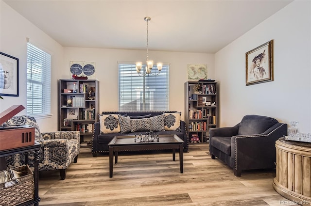 sitting room with light wood finished floors and a notable chandelier